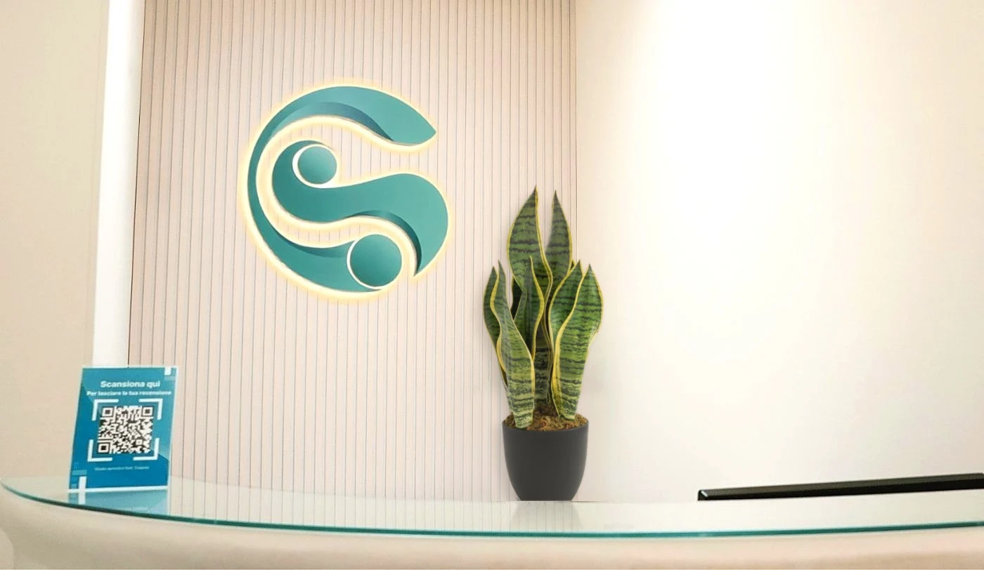 La reception dello Studio Dentistico Coppola ad Alessano, con il logo illuminato sulla parete
